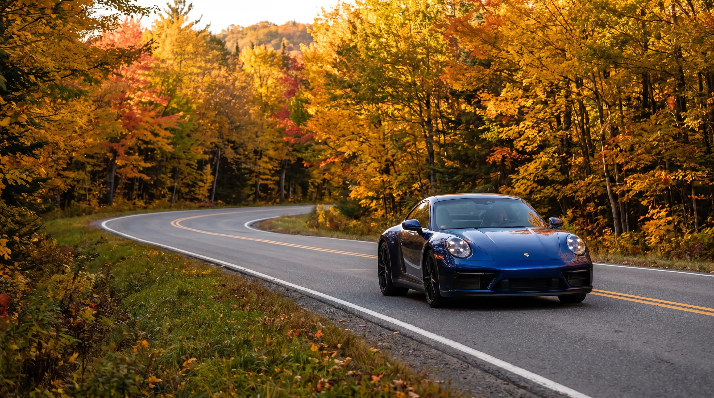 Blue Porsche 911 on a mountain road in the Laurentians in autumn